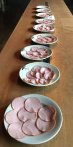 Canadian bacon taste testing in progress. A long table with Canadian bacon samples